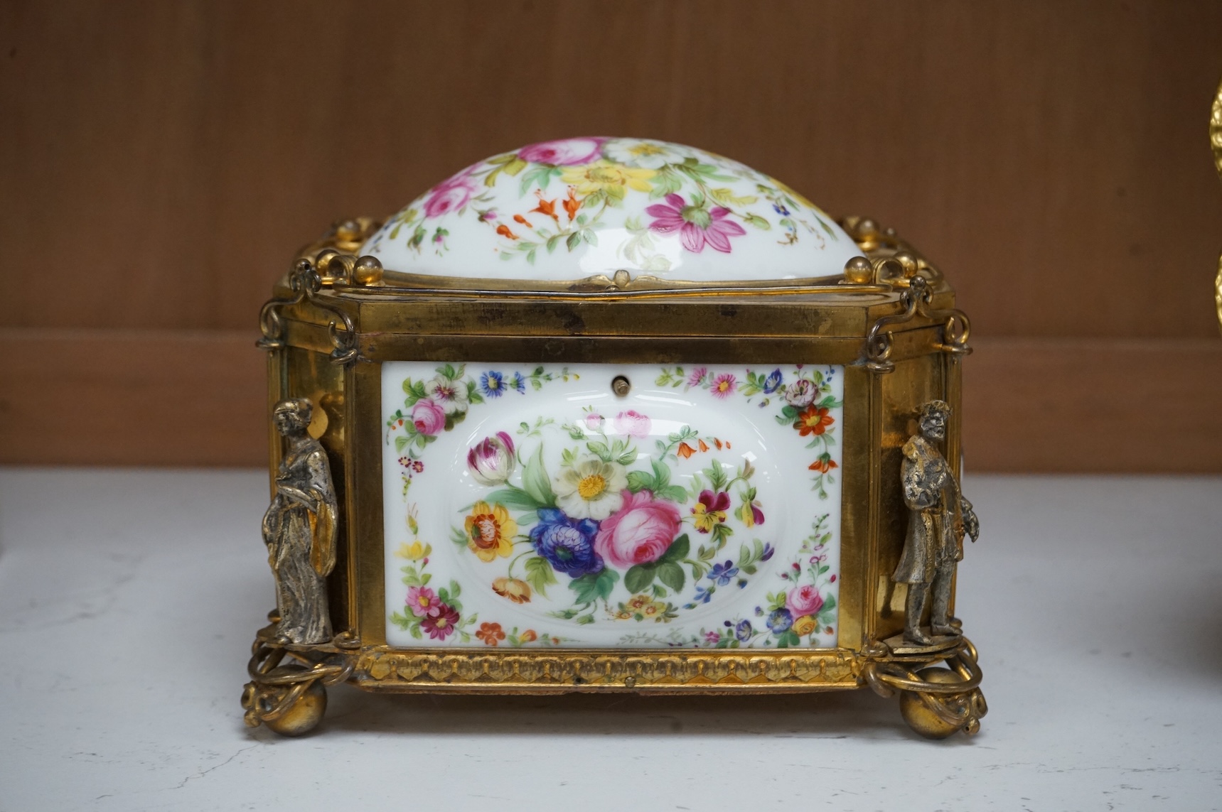 A gilt-brass figural and floral porcelain jewellery casket, 14cm wide, 11cm high.